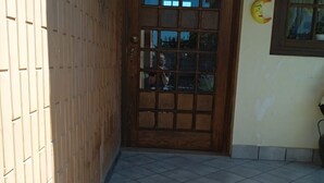 A wooden door with a glass panel, a tiled entrance, and a wall with a crescent moon decoration. - Studio Apartment - Corner 28 (Bolsena)