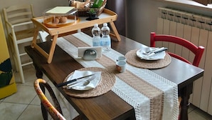 A dining table set with placemats, cutlery, and a tray with cookies. - Studio Apartment - Corner 28 (Bolsena)