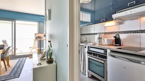 Eine moderne Küche mit Kaffeemaschine, Backofen und einem Essbereich mit Stühlen und Tisch.