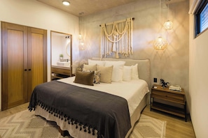A bedroom with a bed, bedside table, wall-mounted macrame, and a wardrobe. - Oceanview Condo · Rooftop Infinity Pool · Walk to Beach & Dining in Punta Mita (Corral del Risco)