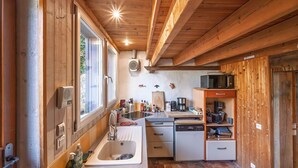 Una cucina compatta con travi in legno, un lavello, un forno a microonde ed una lavastoviglie.