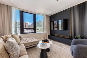 Una sala de estar moderna con sofá, mesa de centro y televisor.