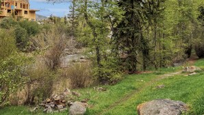 Un paysage naturel avec un bâtiment en construction, une rivière et un sentier.