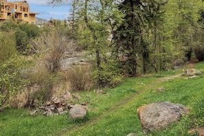 Eine natürliche Landschaft mit einem im Bau befindlichen Gebäude, einem Fluss und einem Weg.
