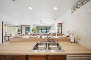 A kitchen with a double sink, wooden countertops, and a view to the outside. - Lakefront Getaway at Bay Point Village (Osage Township)