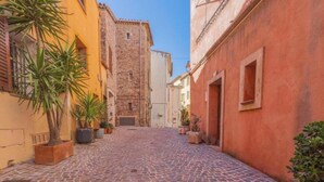 Uma rua de paralelepípedos numa cidade histórica, com edifícios de ambos os lados.