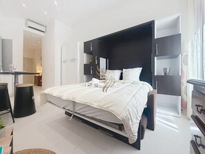 Ein modernes Schlafzimmer mit Bett, Nachttischen und einem Einbauschrank.