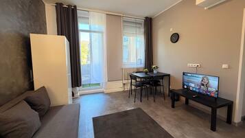 Ein modernes Wohnzimmer mit einer Couch, einem Esstisch und einem Fernseher.