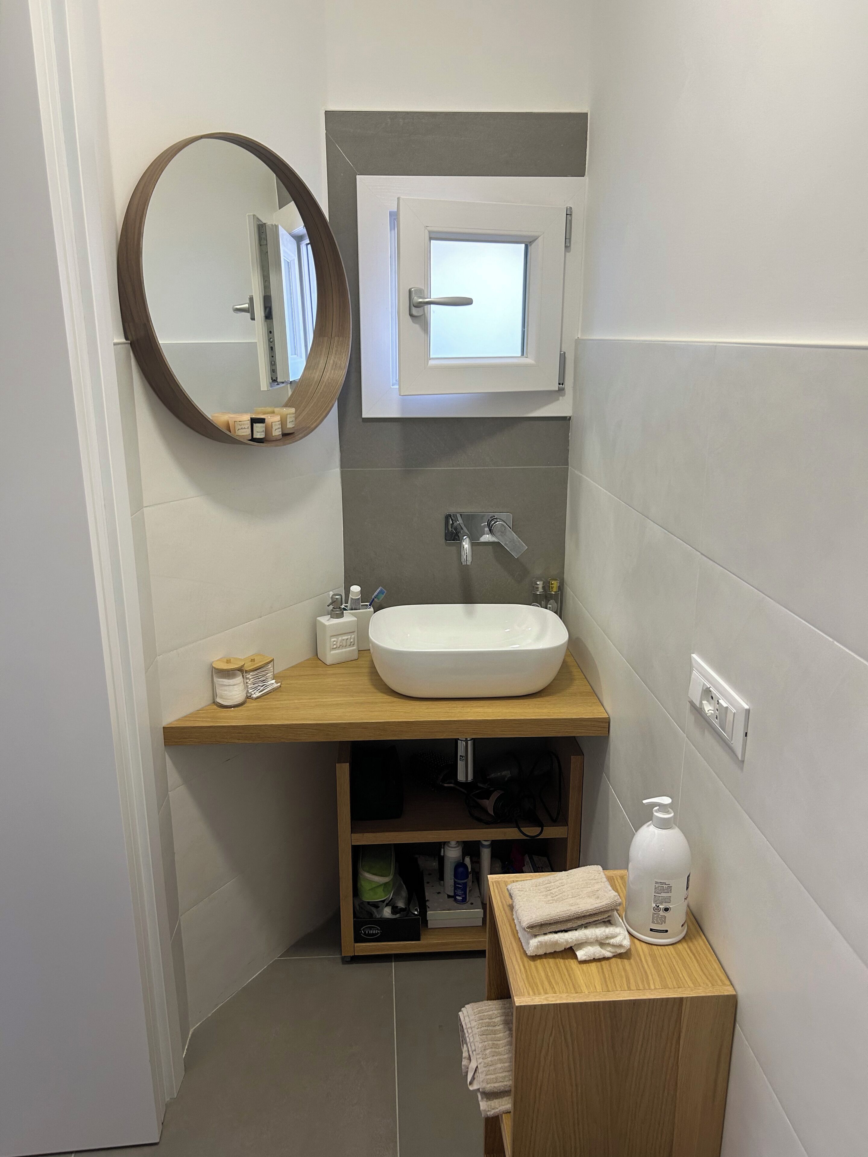 Ein Badezimmer mit Waschbecken, Spiegel, Fenster und Handtuchhalter.