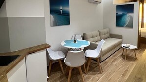 Una cucina moderna con zona pranzo, arredi bianchi e opere d'arte alle pareti.