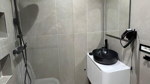 Un bagno moderno con doccia, servizi igienici e lavandino.