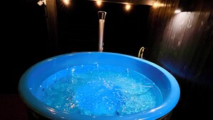 Ein Whirlpool mit Holzverkleidung und einem Metallhahn.