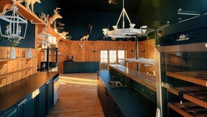 Interior de restaurante con paredes de madera, una isla central y diversas decoraciones de animales.