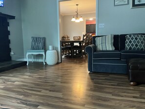 Un salon avec un canapé, un fauteuil, une table et une lampe.