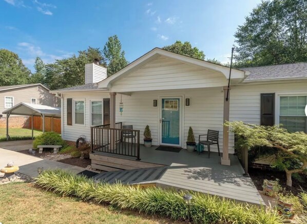 Une maison de plain-pied avec un porche à l’avant, un petit jardin et un garage bien visible.