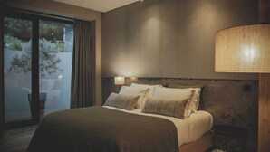 A bedroom with a large bed, a nightstand, a lamp, and a view of greenery outside. - The gateway to the magnificent Douro Valley. High-value wine tourism! (Santa Marta de Penaguião)