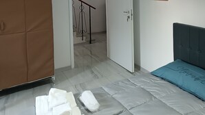 Une pièce comprenant un lit, une armoire, une porte et un escalier menant à une autre pièce.