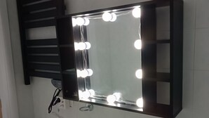 Une salle de bain avec un miroir au-dessus du lavabo, des luminaires et un évier.