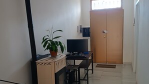 Une pièce comprenant un bureau, une chaise, un téléviseur et une armoire.