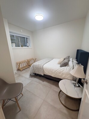 Une chambre à coucher comprenant un lit, une table de chevet, une chaise et une fenêtre donnant sur un paysage agréable.