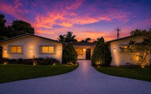 A two-story house with a driveway leading to the front door, surrounded by well-maintained lawns and trees. - Villa Velvet ~ Heated Pool, Jacuzzi, Game Room & Minutes to Beaches (Pembroke Pines)