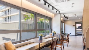 A modern interior with a seating area, large windows, and a view of the outside. - Studio Novo Campo Belo Piscina Congonhas Moema (São Paulo)