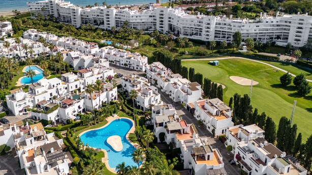 Un complexe hôtelier comprenant plusieurs bâtiments blancs, une piscine et un parcours de golf.
