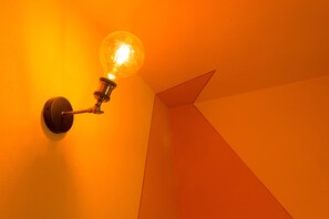 Un luminaire mural avec une ampoule visible.