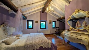 Ein Schlafzimmer mit einem Bett, einem Schminktisch, einem Spiegel und einer Deckenleuchte.