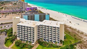 Un hôtel à plusieurs étages avec vue sur la plage, un parking et un espace piscine.