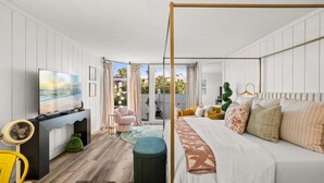 Une chambre à coucher avec un lit, une télévision, un bureau et une vue sur l’extérieur.