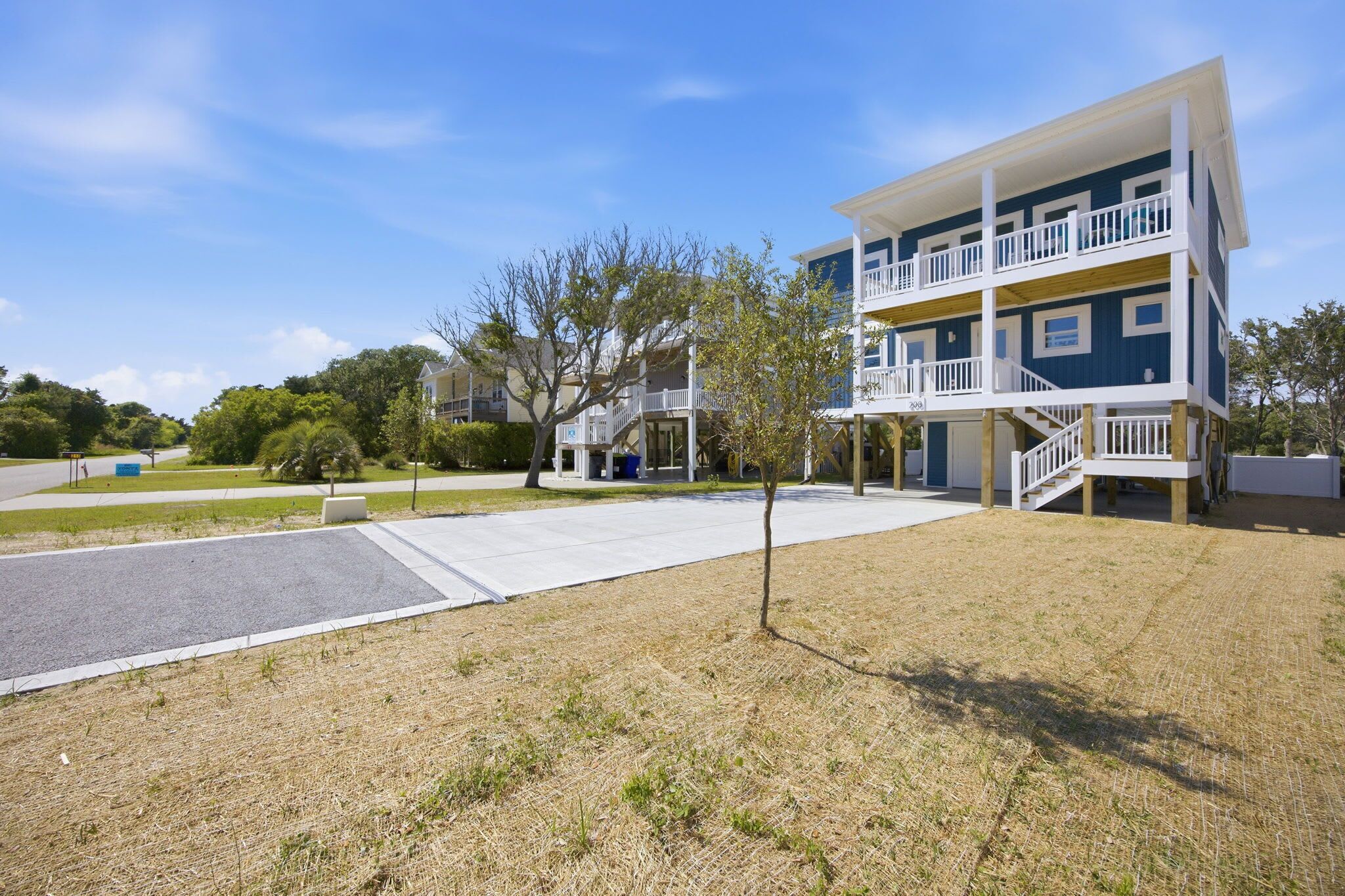 A multi-story building with a balcony, a covered walkway, and a parking area.