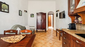 A kitchen with a wooden cabinet, a dining table, and chairs. - Cozy apartment near the port of Trapani and the city beaches (Trapani)