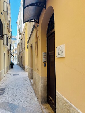 A narrow street with yellow buildings, a closed door, and a sign indicating '7 floors.' - Cozy apartment near the port of Trapani and the city beaches (Trapani)