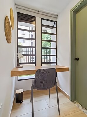 A room with a desk, chair, and a window with blinds. - Casa Velasquez 101 (Medellín)