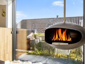 Ein modernes Zimmer mit Kamin, großen Fenstern und Blick auf eine Wohngegend.