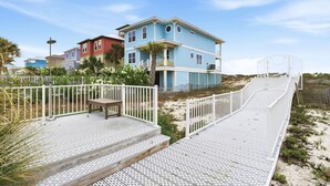 A beachfront property with a wooden deck, a white fence, and a blue building. - Mustique 2001 (Gulf Shores)