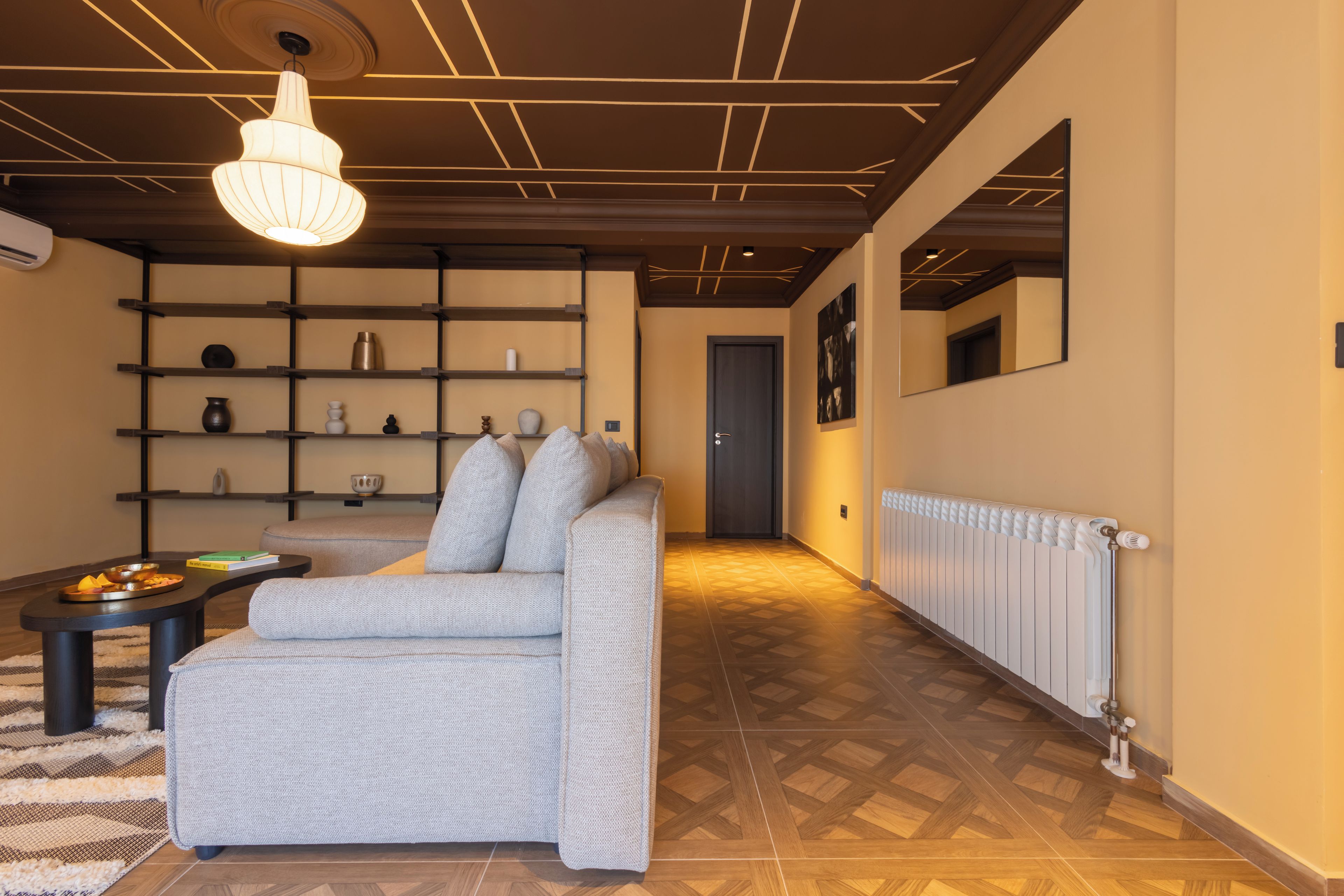 A modern living room with a sofa, a coffee table, and a bookshelf.