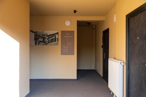 Un pasillo con un radiador, un cartel y una puerta.
