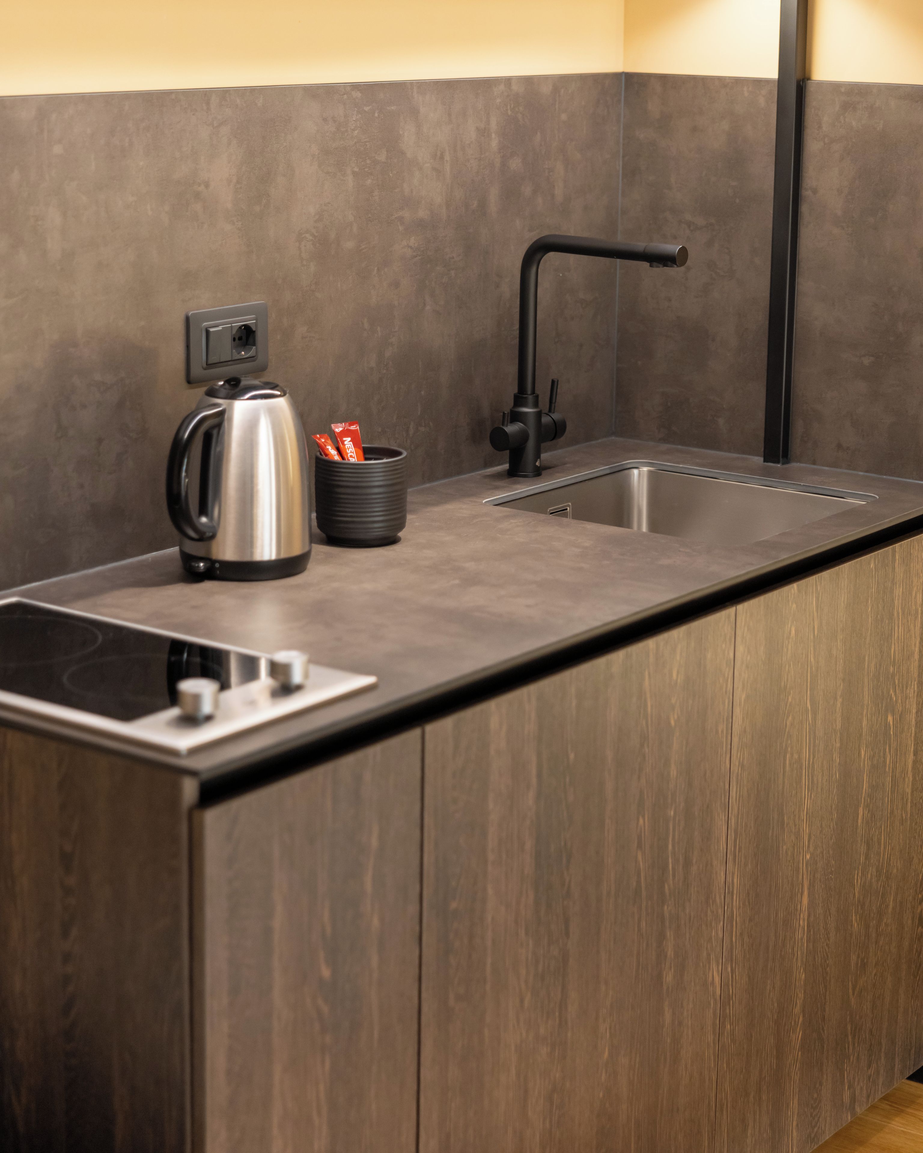 Cocina moderna con pileta integrada, tetera y cafetera.