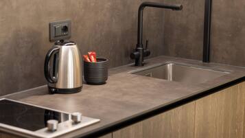 Cocina moderna con pileta integrada, tetera y cafetera.