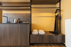 Un baño moderno con tocador de madera, toallero y zona de ducha.