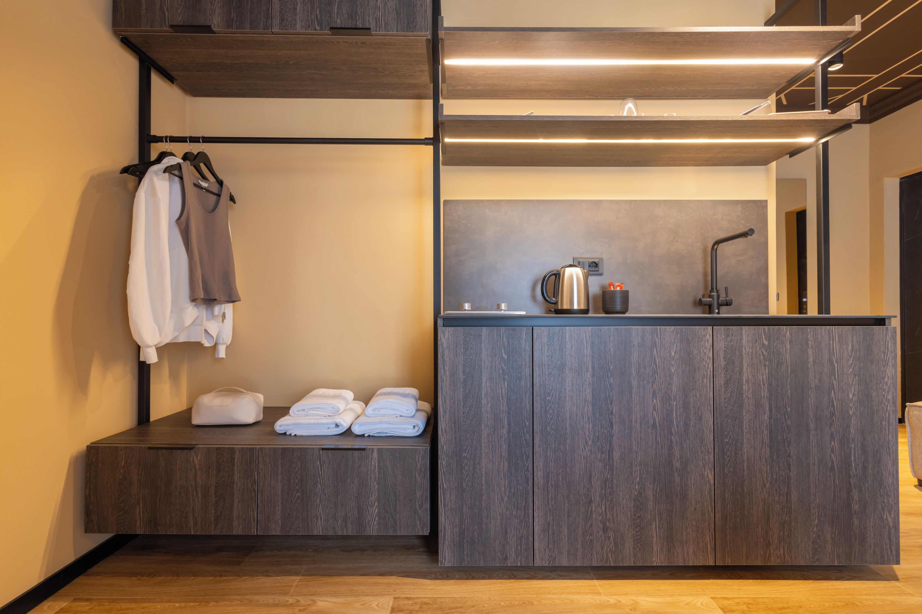 A modern bathroom with a built-in sink, a towel rack, and a mirror.