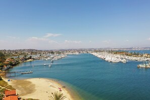 Ein Yachthafen mit Booten, einem Strand und einer Stadtkulisse im Hintergrund.