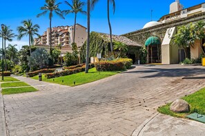 A paved pathway leading to a building with a dome and a green awning. - Velas Resort Access Beachfront 3BR Condo (Puerto Vallarta)