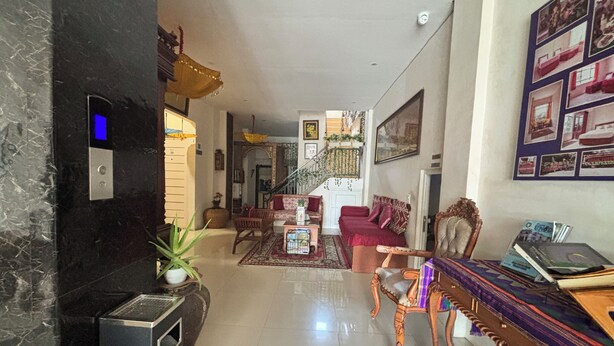 A spacious living area with a sofa, a coffee table, and a fireplace. There is a staircase leading to an upper level. - Townhouse Oak near RSUD Dr. Zainoel Abi (Banda Aceh)
