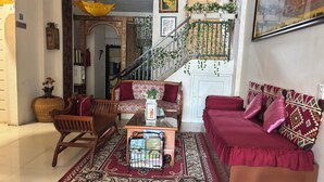 A living room with a sofa, chairs, a coffee table, a staircase, and a hanging plant. - Townhouse Oak near RSUD Dr. Zainoel Abi (Banda Aceh)