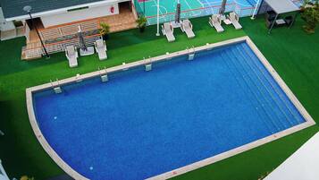 Una piscina al aire libre, sombrillas, guardavidas en la propiedad