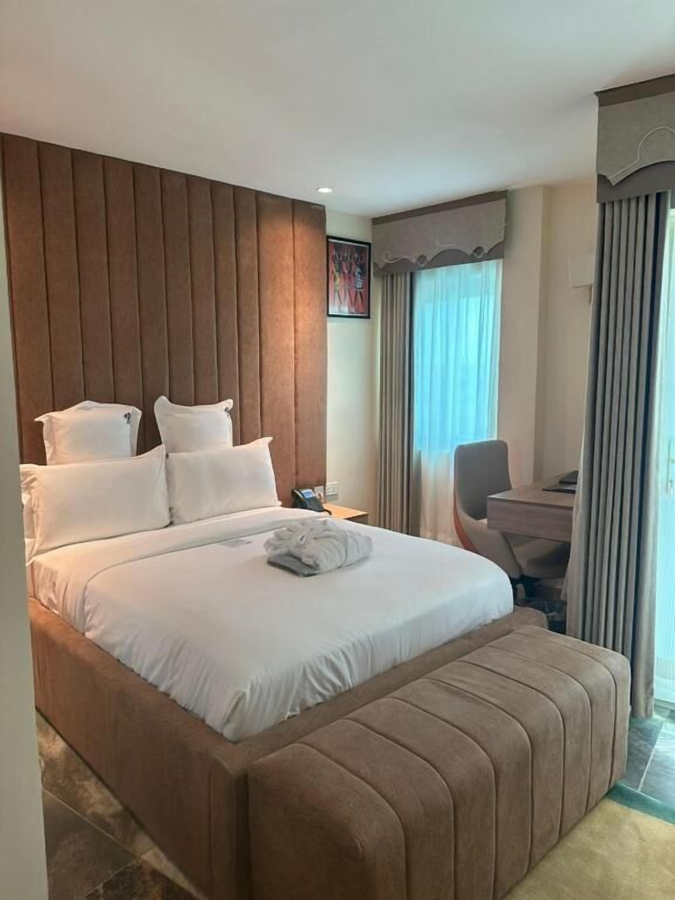 Una habitación de hotel con una cama grande, un escritorio y una silla.