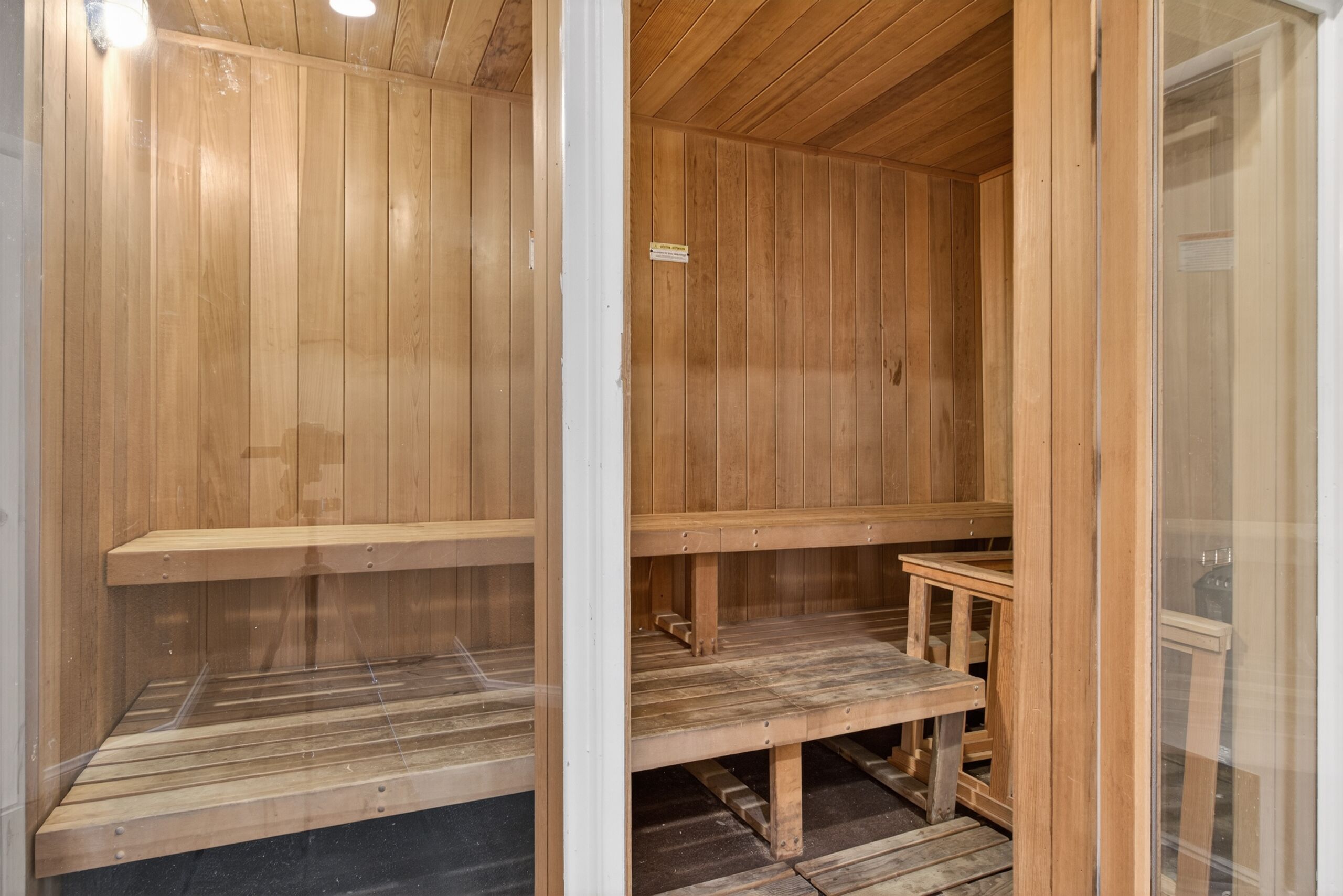 Un sauna en bois avec des bancs et une petite table.